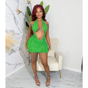 Detail of emerald green halter neck mini dress with ruffled hem and cut-out waist design