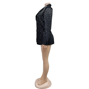 Detail of elegant black blazer featuring intricate white pearl beaded shoulders and sleeves