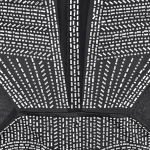 Dettaglio macro dell'abito in rete nera con strass argentati e decorazioni di borchie