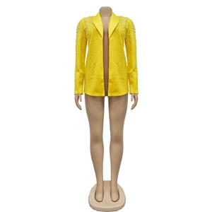 Detail of elegant white pearls hand-sewn on a bright yellow notched lapel blazer jacket
