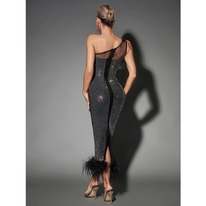 Back view of a black one-shoulder rhinestone dress with mesh detail and feather trim
