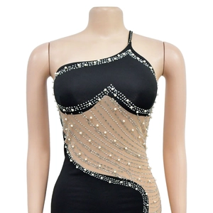 Détail de la robe courte en maille noire avec perles élégantes et strass brillants