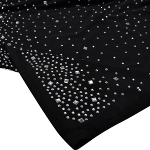 Detailed view of shimmering silver rhinestones on black mesh fabric for elegant evening dress