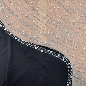 Détail de l'assemblage en résille avec perles et strass sur une mini robe de soirée
