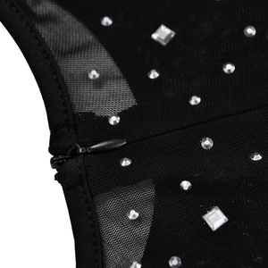 Macro detail of black mesh dress featuring sparkling rhinestones and invisible zipper