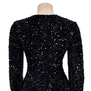 Close-up of black sequin dress featuring long sleeves and a hidden back zipper detail