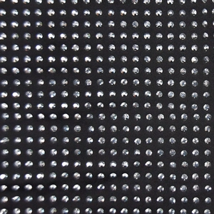 Macro shot of silver rhinestones in a mesh grid on black bandage dress fabric