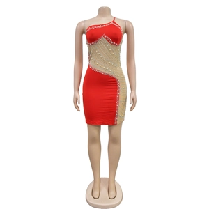 Détail d'une mini-robe en tulle rouge ornée de perles luxueuses et de strass