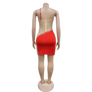 Détail d'une robe moulante rouge avec dos en tulle transparent, paillettes et perles