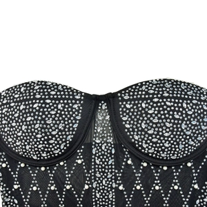 Detail of black mesh corset top featuring sparkling rhinestones and white pearls