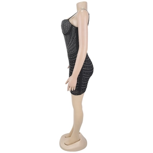 Dettaglio del mini abito aderente nero con strass scintillanti e texture in rete velata
