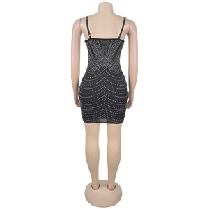 Dettaglio mini abito nero in mesh con motivi a onde di strass scintillanti sul retro