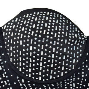 Dettaglio abito in rete nera con strass argento verticali in forme rotonde e a baguette