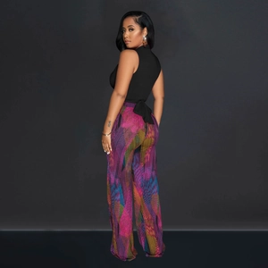 Detail of high-neck sleeveless black top with tie-back and colorful geometric wide-leg pants