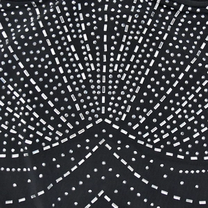 Dettaglio macro di strass geometrici su tessuto a rete nero per questo abito