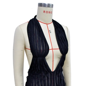 Detail of black halter top featuring deep V-neck and textured pleated fabric design