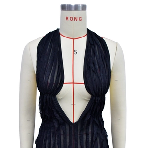 Detailed view of black deep V-neck top with pleated texture and mesh fabric