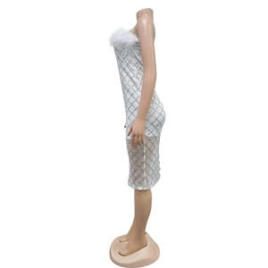 Close-up of white tube dress with faux fur trim and silver sequin diamond patterns
