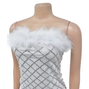 Close-up of white feather trim and silver sequin diamond patterns on a tube dress