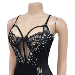 Dettaglio di body nero con strass decorativi, pizzo e inserti in rete velata