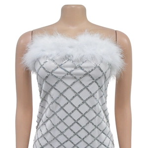 Close-up of white sequin tube dress featuring feather trim and silver diamond patterns