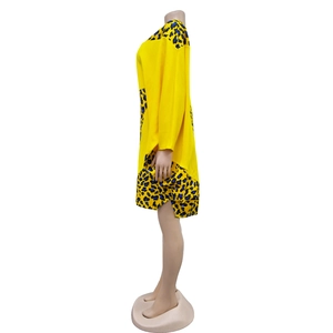 Detail of yellow knit dress featuring contrasting blue leopard print sleeves on a mannequin