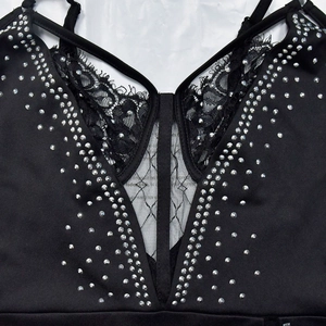 Dettaglio dell'abito nero con scollo a V con strass scintillanti e pizzo delicato