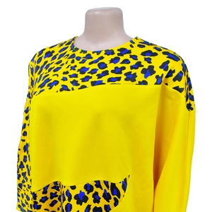 Detail of round neck top with bright yellow fabric and leopard print color blocking