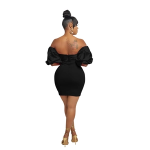 Detail view of the elegant open back design on a black off-shoulder puff sleeve dress