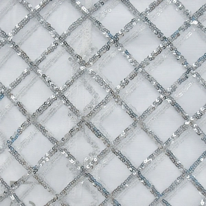 Macro shot of white mesh fabric featuring silver sequins arranged in a diamond pattern