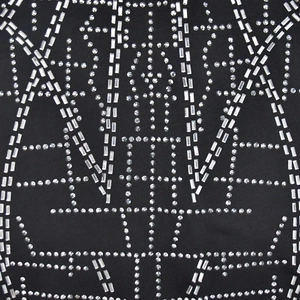 Dettaglio di ricamo geometrico con strass argentati su abito in rete nera