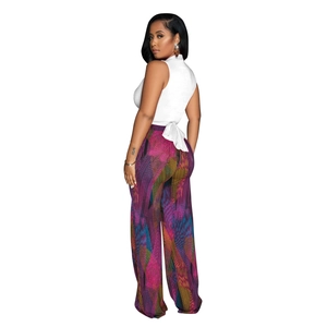 Detail of white sleeveless halter top with back tie paired with colorful print wide leg pants