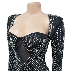 Detailansicht von transparentem Mesh und glitzernden Silber-Strasssteinen am schwarzen Kleid
