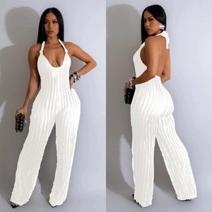 Detail of white plissé halter neck jumpsuit featuring a deep V-neck and backless design