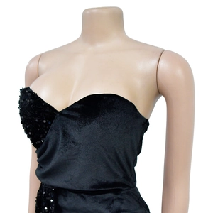 Détail de la robe noire à paillettes montrant le décolleté cœur et la texture velours