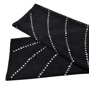 Close-up of sheer black mesh sleeves featuring sparkling rhinestones and clean-cut edges