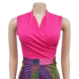 Detail of fuchsia V-neck sleeveless top and colorful geometric striped trousers set