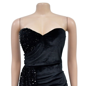 Détail d'une robe de soirée bustier noire en velours avec sequins et design drapé chic