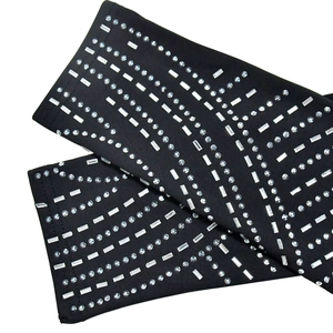 Detail aus schwarzem Netzstoff mit luxuriösen Strass-Kristallstreifen am Ärmel