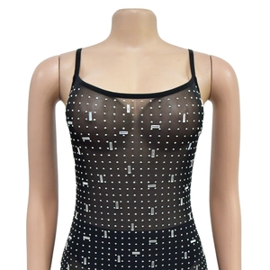Détail d'un body en maille noire transparente orné de strass argentés et de cristaux brillants