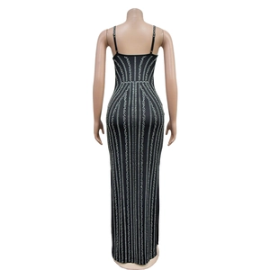 Detail of the back view of a slim black maxi dress featuring vertical rhinestone patterns