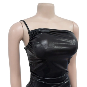 Détail de robe noire métallique avec fines bretelles et textures plissées sur le côté