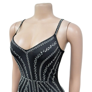 Detail of silver rhinestones in a sunburst pattern on a black bodycon strap dress