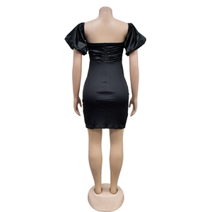 Detail view of backless black mini dress featuring pleated waist and puff sleeves