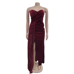 Détail de la robe en velours bordeaux avec sequins, plis à la taille et fente latérale