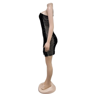 Detail view of the black sequin mini dress featuring draped silver chain side accents