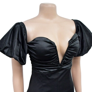 Detail of black satin dress featuring a deep V-neckline and elegant ruched puff sleeves