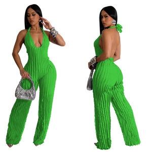 Detail of lime green pleated jumpsuit featuring halter deep V-neck and open back design