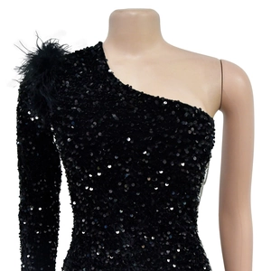 Detail of black sequined dress featuring elegant feather shoulder and shimmering texture