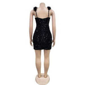 Detail of black sequin mini dress with elegant feather straps and shimmering texture